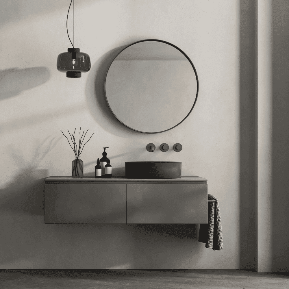 Modern bathroom design featuring a round mirror, sleek cabinetry, and stylish accessories, highlighting custom glass options for shower doors and mirrors.