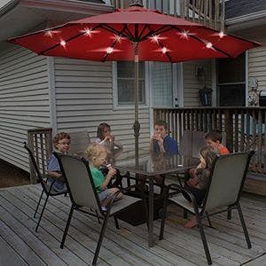 Patio with glass tabletop and open red umbrella