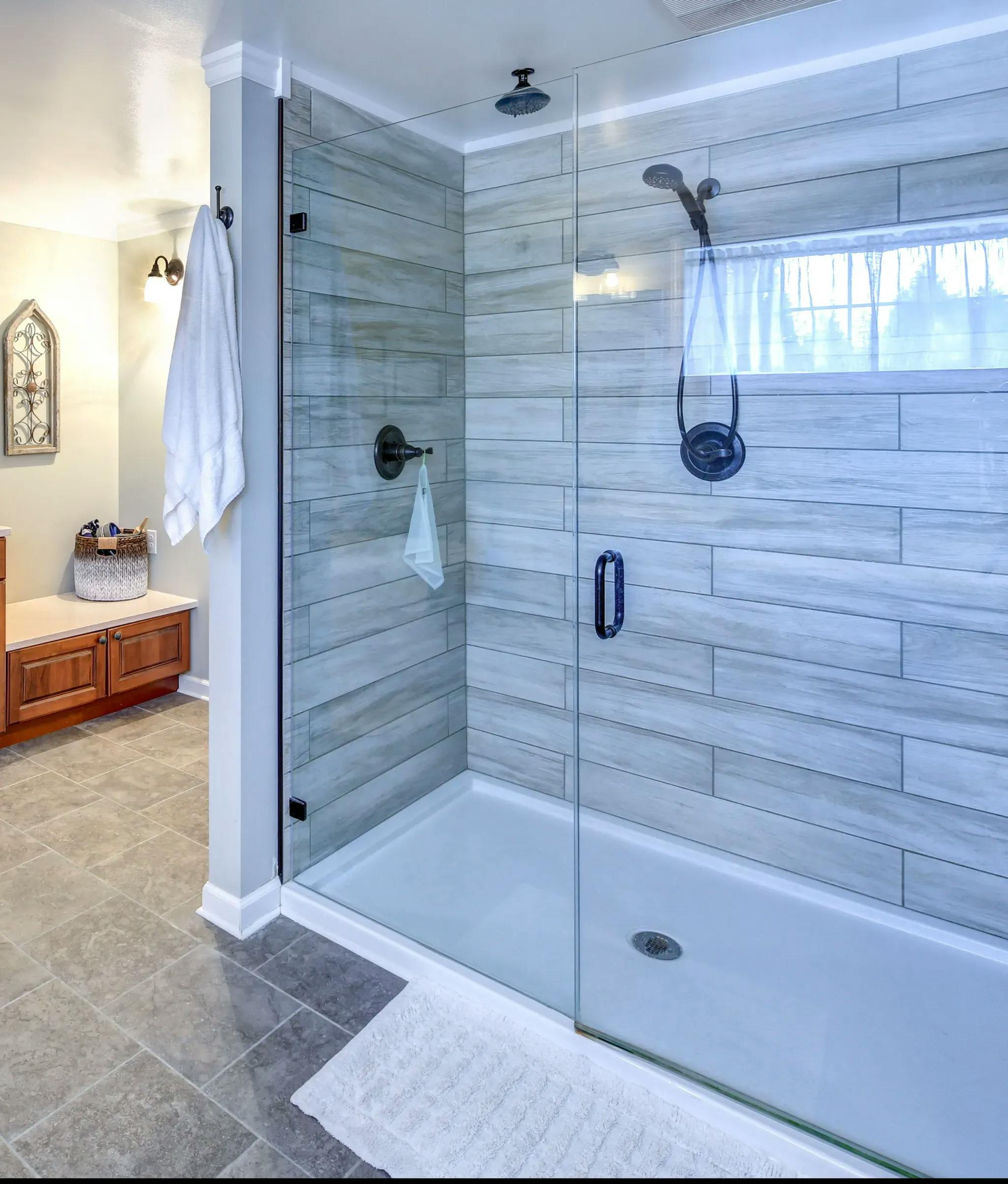 Bathroom setting featuring the Prima glass shower door model with clear glass and black shower door hardware.