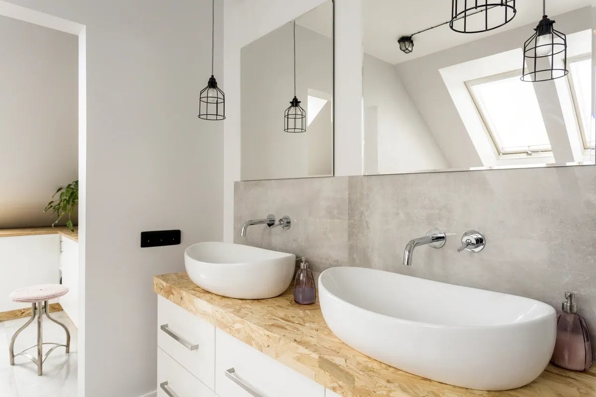 Double vanity sink area with two rectangle mirrors above each of the two sinks. Natural material design theme 