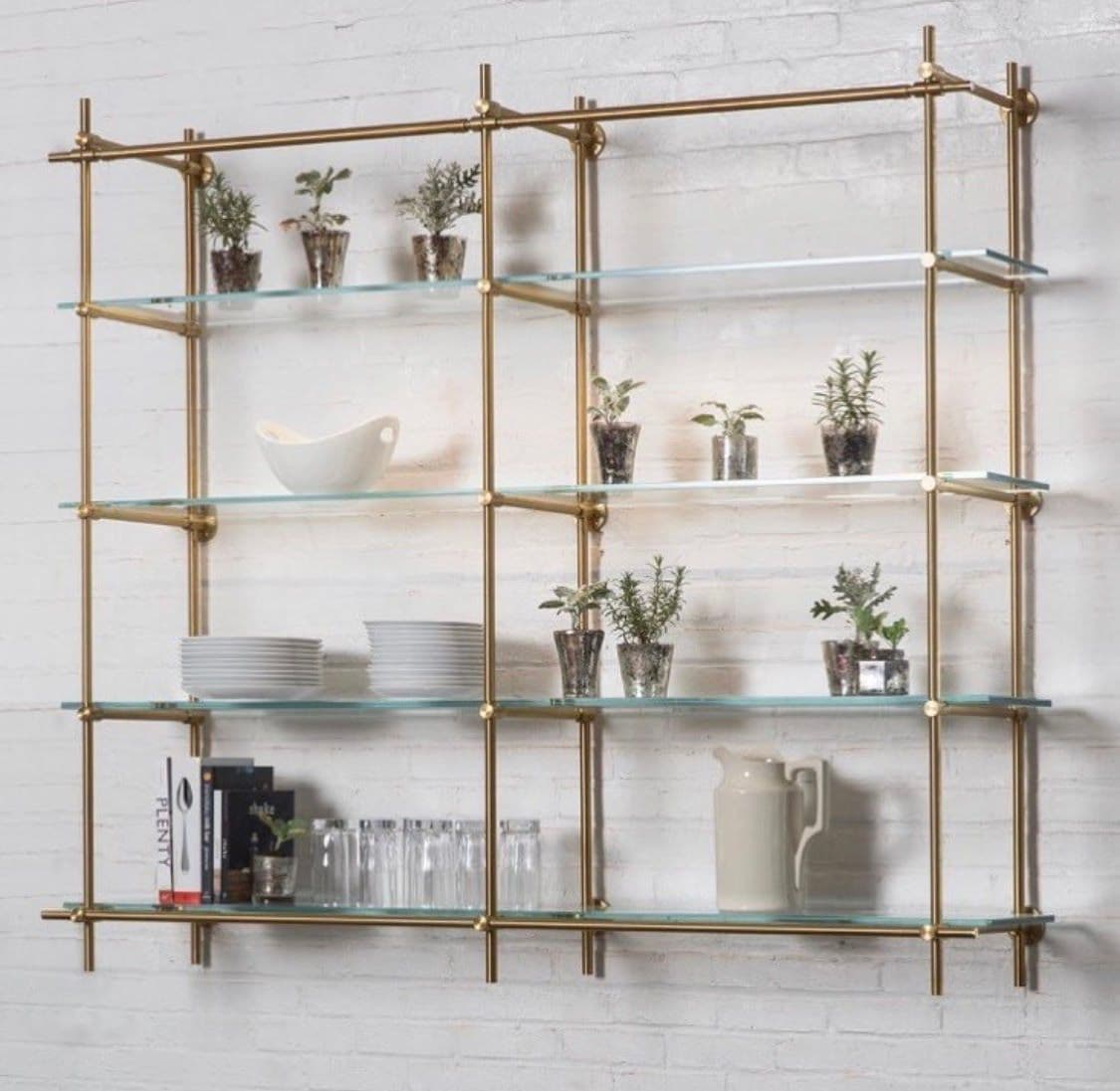 Modern glass shelving unit with brass accents, featuring custom glass shelves ideal for displaying plants, dinnerware, and decor.
