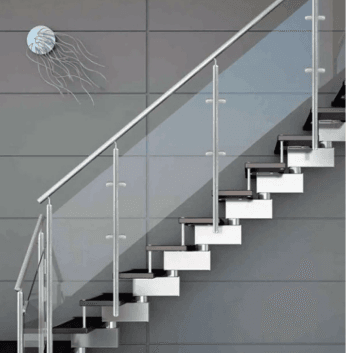 Glass railing on modern stairs with chrome handrail, against a backdrop of large grey wall tiles