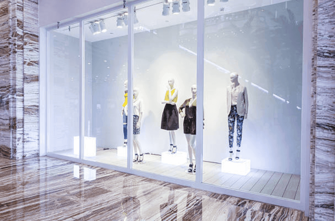 Modern retail display showcasing mannequins in a glass storefront with sleek custom glass panels, highlighting the elegant use of tempered glass.