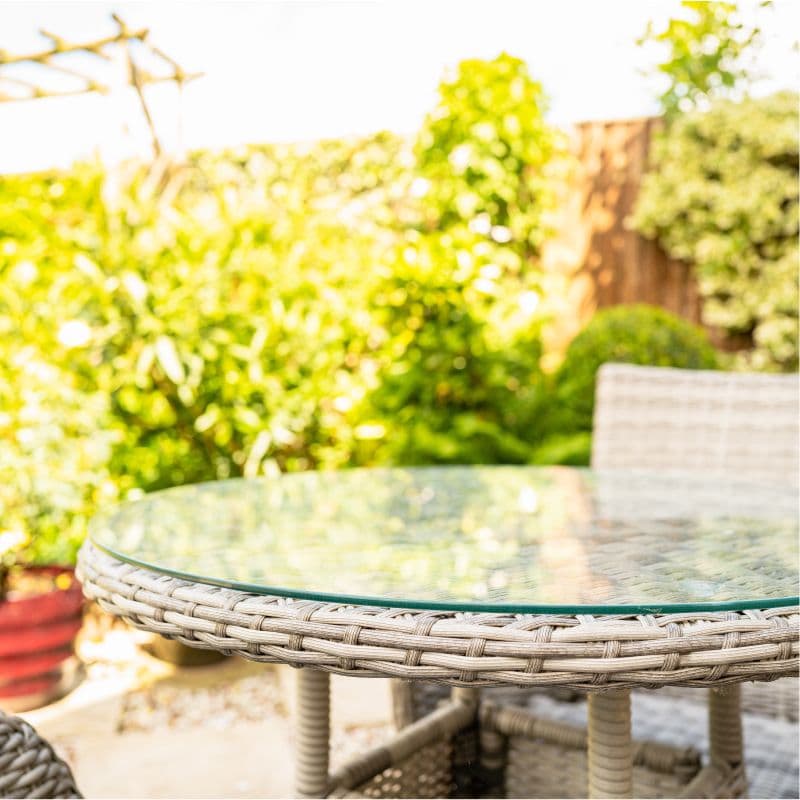 Custom glass table top with beveled edges in a garden setting, showcasing tempered glass design.