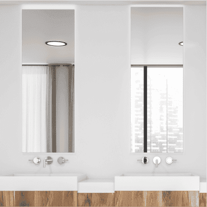 Two tall rectangular mirrors above white sinks on white walls