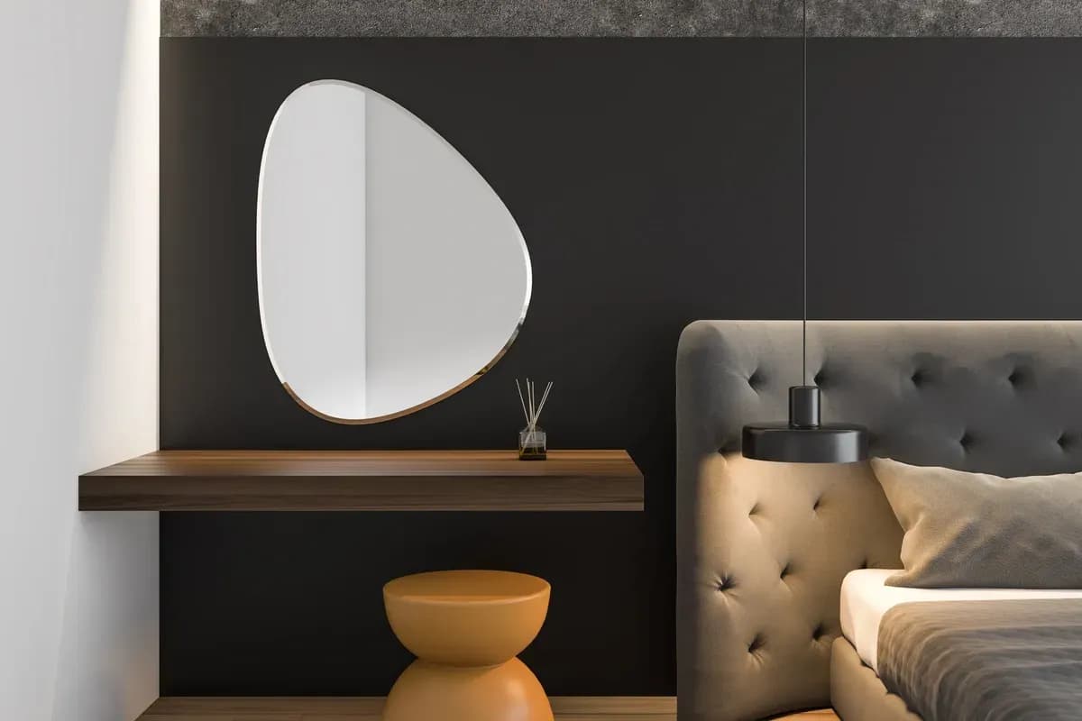 Modern interior featuring a uniquely shaped mirror with a beveled glass edge above a sleek wooden table, showcasing custom glass design elements suitable for mirrors and contemporary decor.