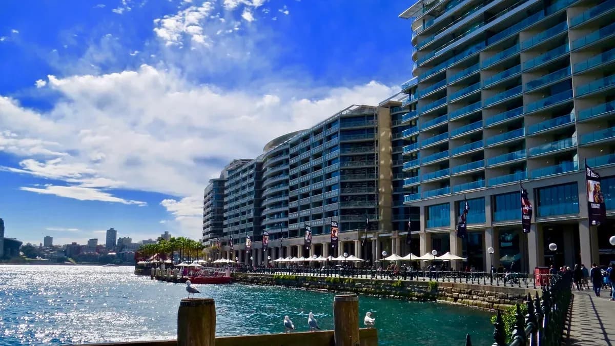 Modern waterfront buildings beside a shimmering waterway, showcasing views ideal for custom glass features like shower doors, table tops, and mirrors.