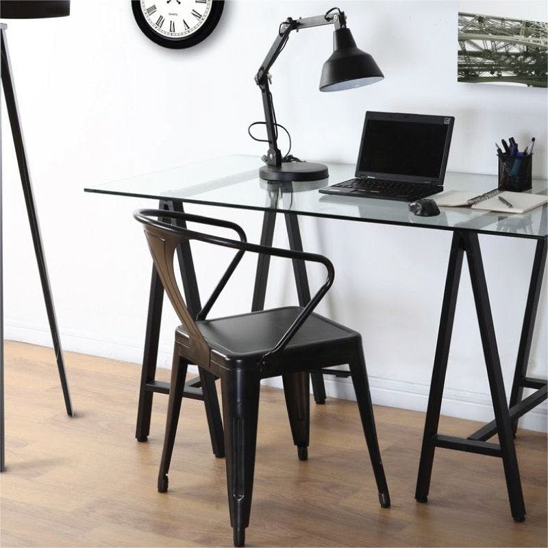 A sleek black chair and a laptop placed on a glass desk, creating a modern and stylish workspace.