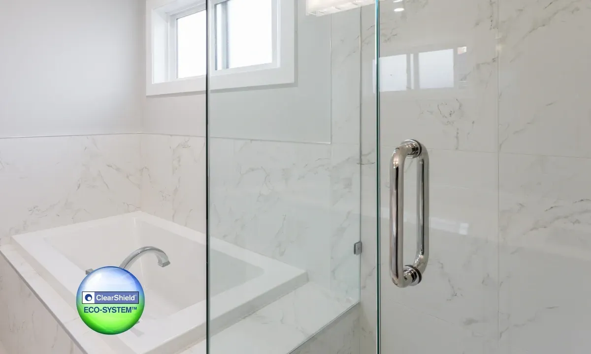Modern shower doors with clear tempered glass, featuring a sleek handle, set in a stylish bathroom with marble walls, highlighting custom glass solutions.