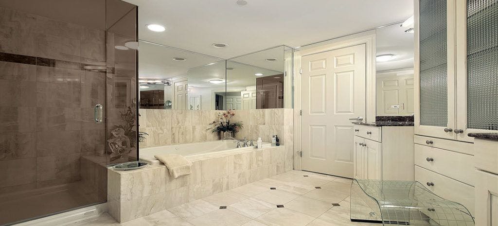 bronze tinted corner shower door in a white marbled bathroom