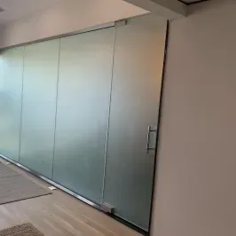 Modern custom shower doors made of tempered glass, featuring a sleek design suitable for contemporary bathrooms.