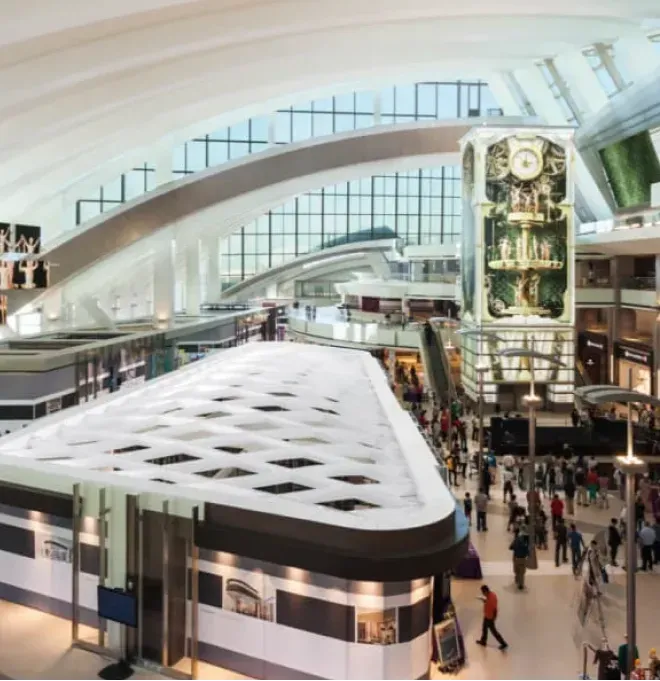 Interior view of a modern airport featuring custom glass installations, large glass windows, and spacious design elements, highlighting the use of tempered glass and innovative architectural features.