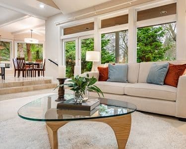 Elegant living room featuring a custom glass tabletop, surrounded by modern decor, showcasing the beauty of tempered glass and a serene atmosphere, perfect for home aesthetics.