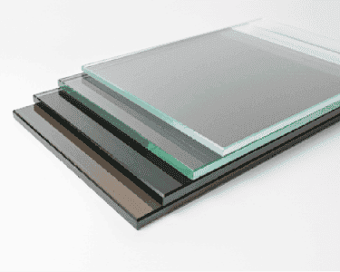 Various sheets of custom tempered glass, showcasing different finishes for shower doors, table tops, and mirrors with beveled glass edges.
