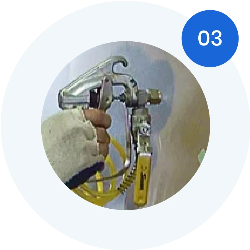 Hand holding a spray gun for applying finishes to custom glass, emphasizing precision in glass work for shower doors, table tops, and mirrors.