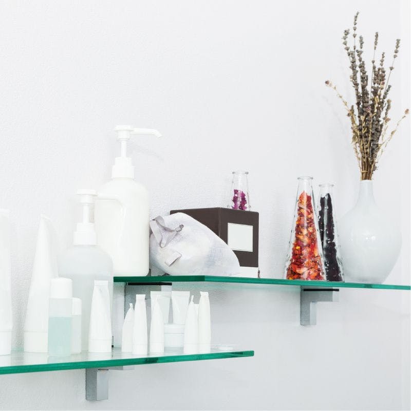 Two decorative glass shelves showcasing a vase and bottles, enhancing the aesthetic appeal of the room.