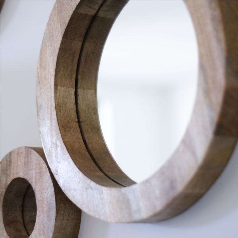 Circular wooden frame with mirror reflecting light