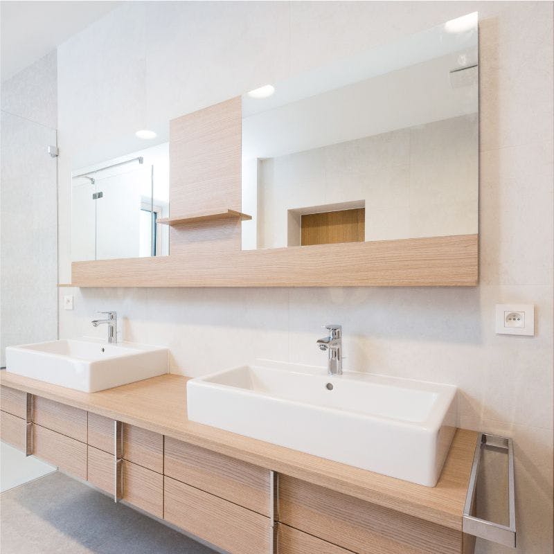 A modern bathroom featuring two sinks and two vanity mirrors