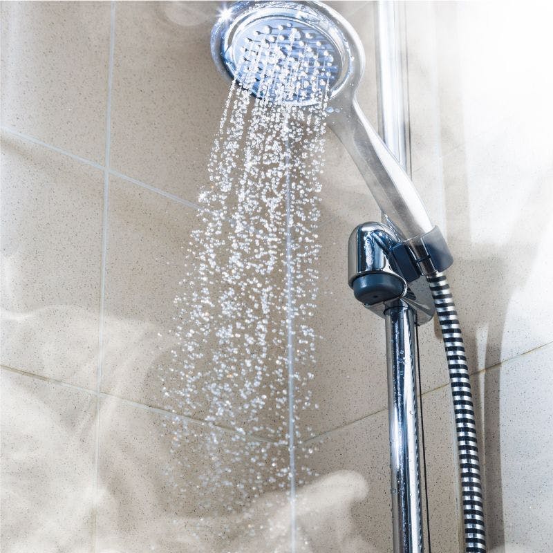 A shower head releasing steam, creating a relaxing and invigorating atmosphere in the bathroom