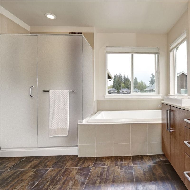 Spacious bathroom with tub and shower with glass shower doors