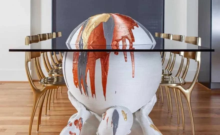 Custom glass tabletop with a unique artistic base, showcasing creativity and design, surrounded by contemporary chairs.