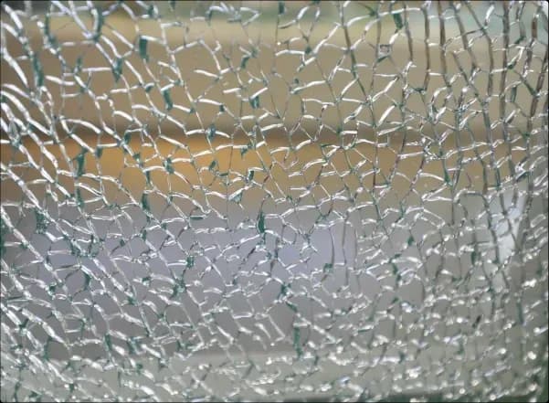 Fragmented glass surface with a unique pattern, showcasing custom glass options for shower doors, table tops, and mirrors. Ideal for tempered glass and beveled glass edge applications.
