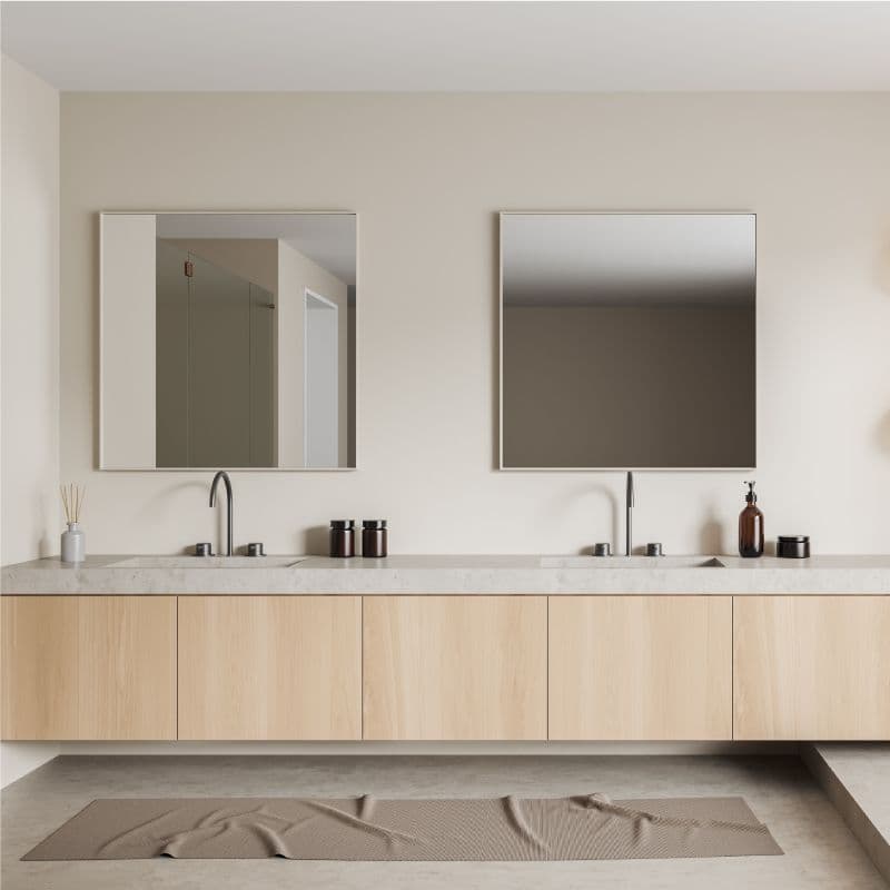 Modern bathroom featuring custom mirrors above a sleek vanity with a marble countertop, showcasing tempered glass elements and a minimalist design.