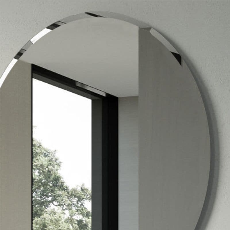 Round beveled mirror on bathroom wall