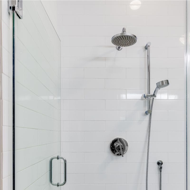 A modern shower with a glass door and a sleek shower head