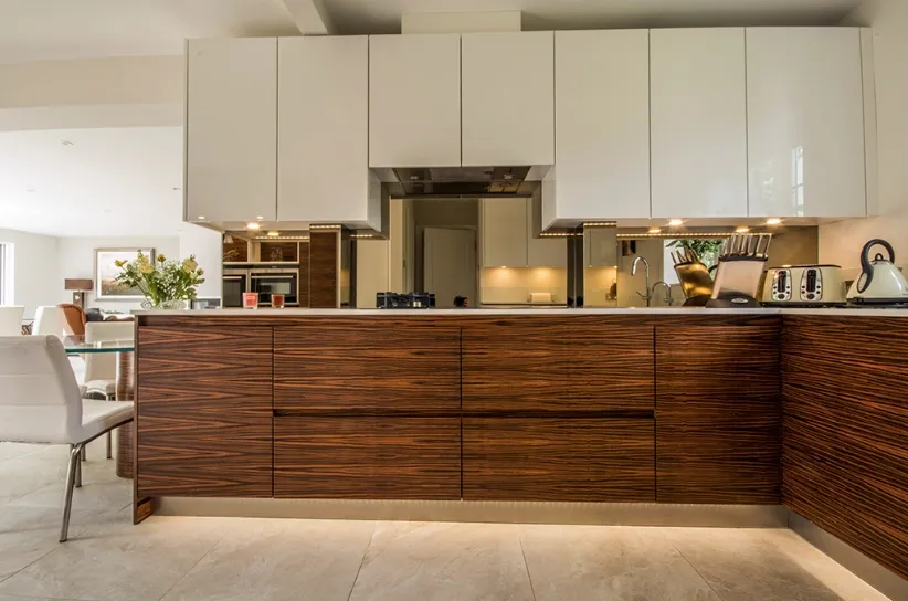 Modern kitchen with elegant cabinetry, showcasing custom glass countertops and integrated mirrors, highlighting tempered and beveled glass edges.