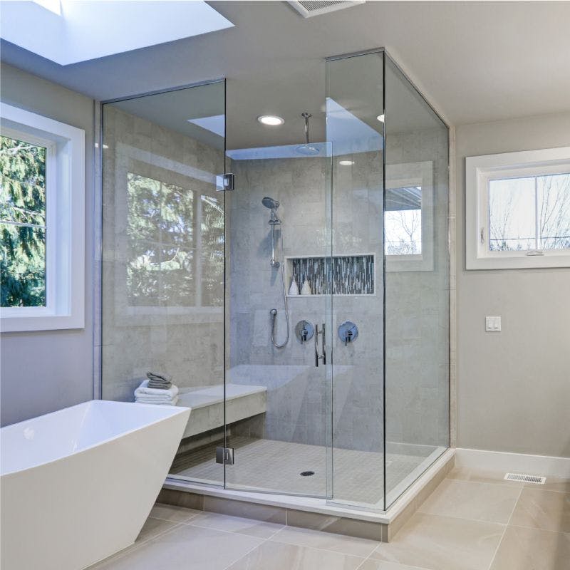 A spacious bathroom featuring a transparent glass shower door, providing a modern and open feel to the room.