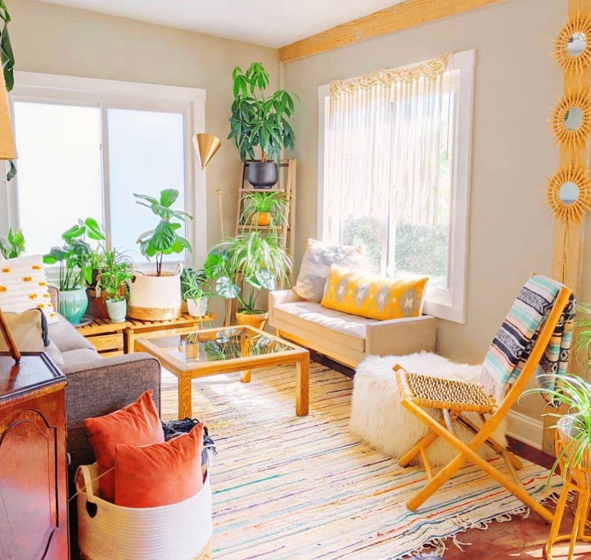 Bright and airy living room featuring a glass coffee table, surrounded by plants, with cozy seating, ideal for showcasing custom glass decor, including mirrors and tempered glass elements.