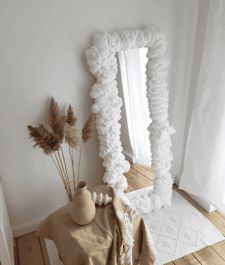 Elegant mirror with unique textured frame in a serene setting, showcasing custom glass design potential for stylish interiors.
