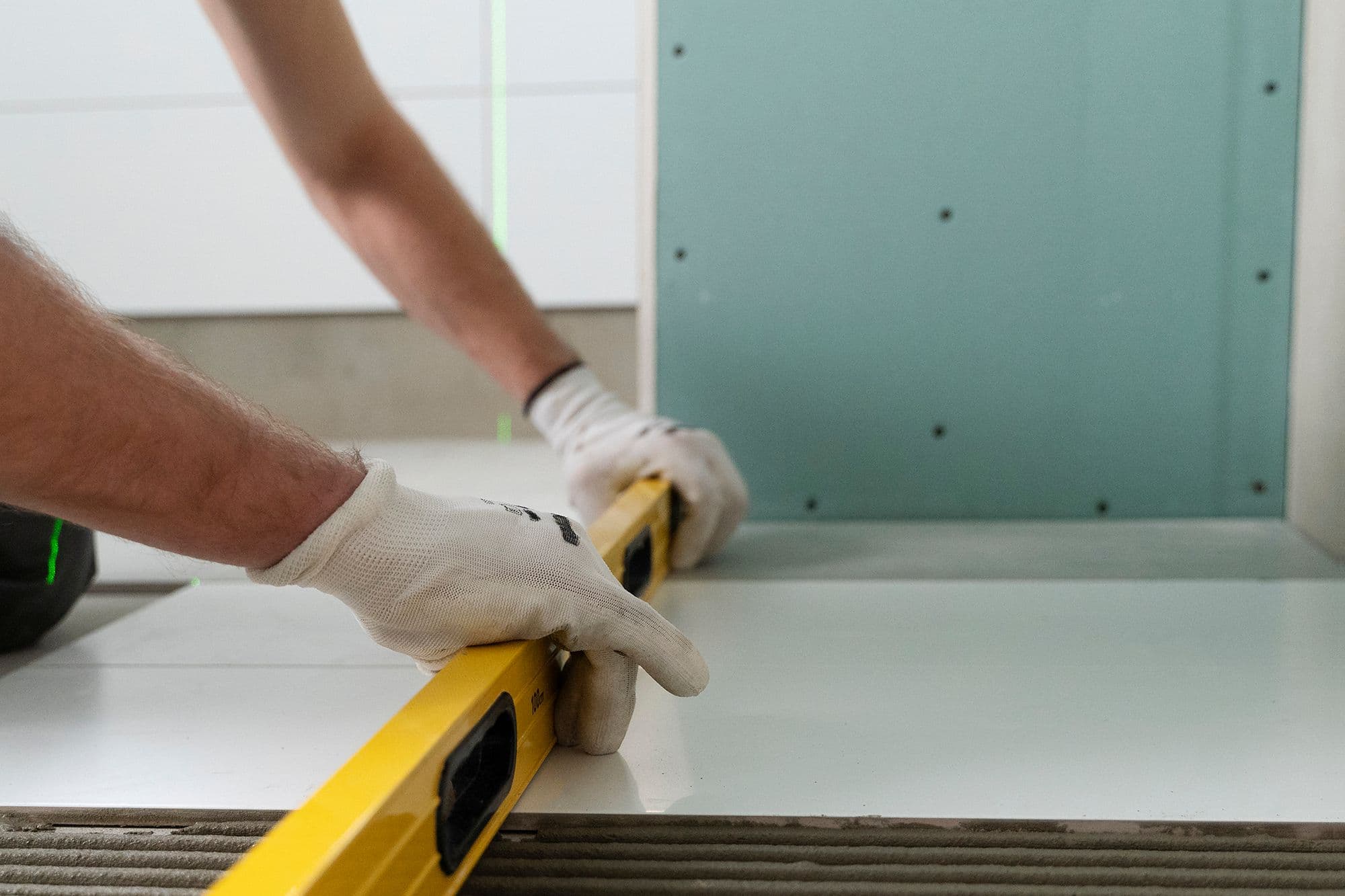 Using a 4-foot level to check that a shower threshold is level