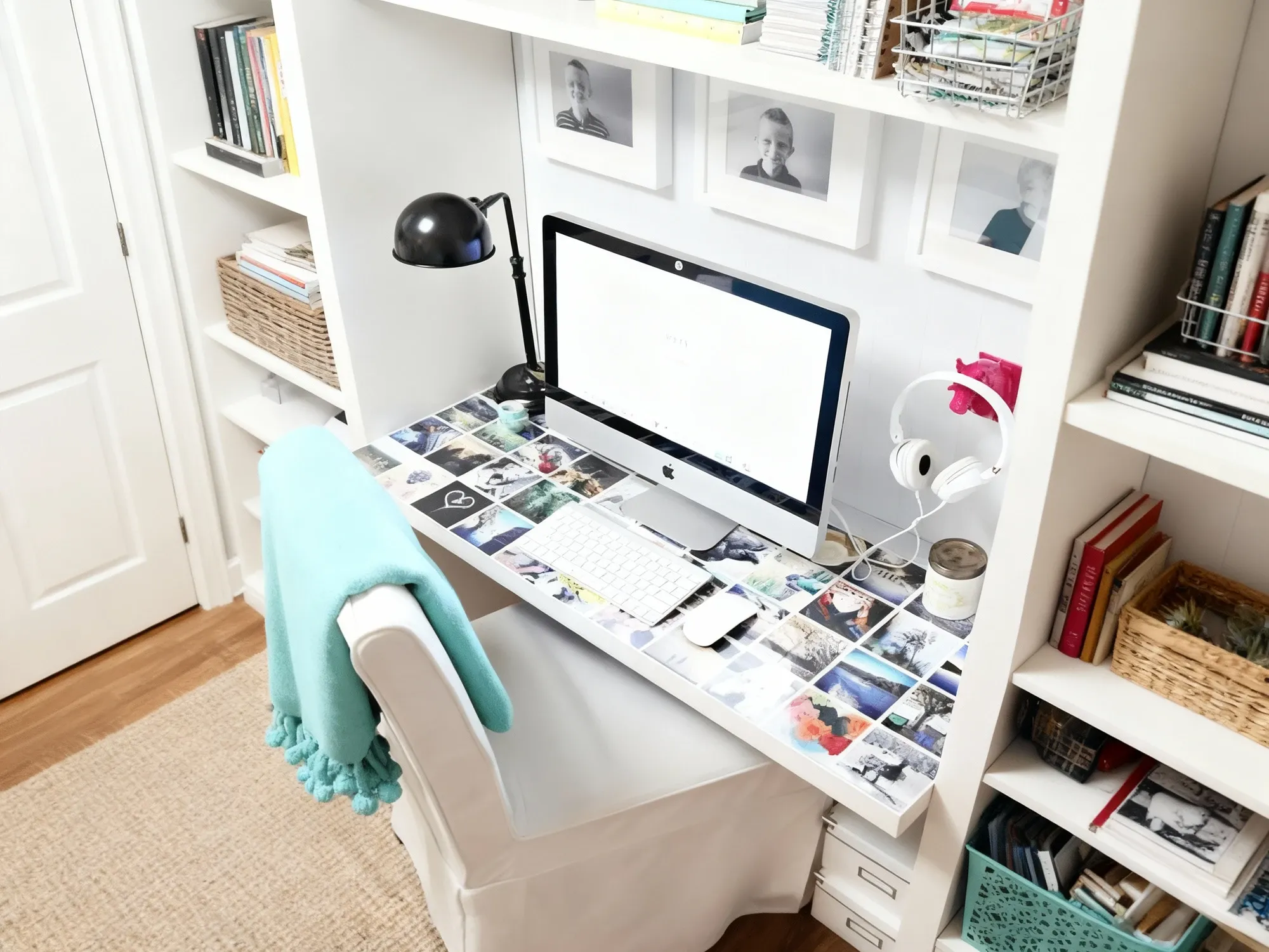 A home office desk with a photo collage protected by a clear plexiglass sheet, creating a personalized and durable workspace.
