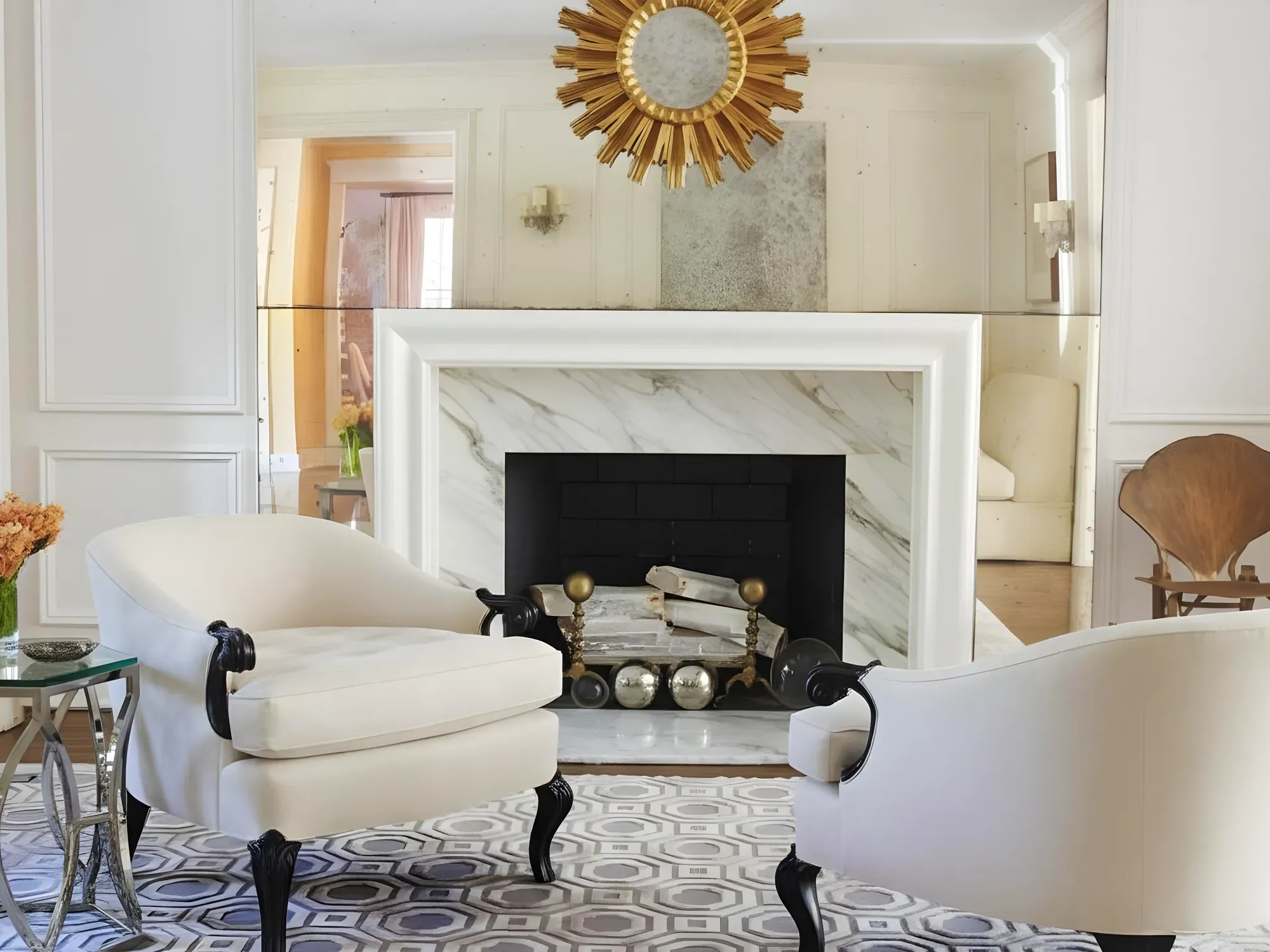 An elegant living room featuring a custom-cut mirrored wall, or backsplash, installed above a white marble fireplace.