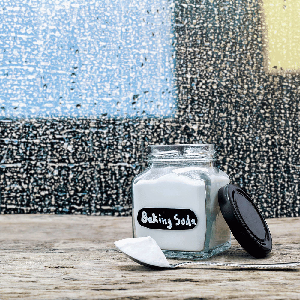 A glass jar labeled Baking Soda with a spoon beside it, set against a colorful textured background, emphasizing the clarity of custom glass.