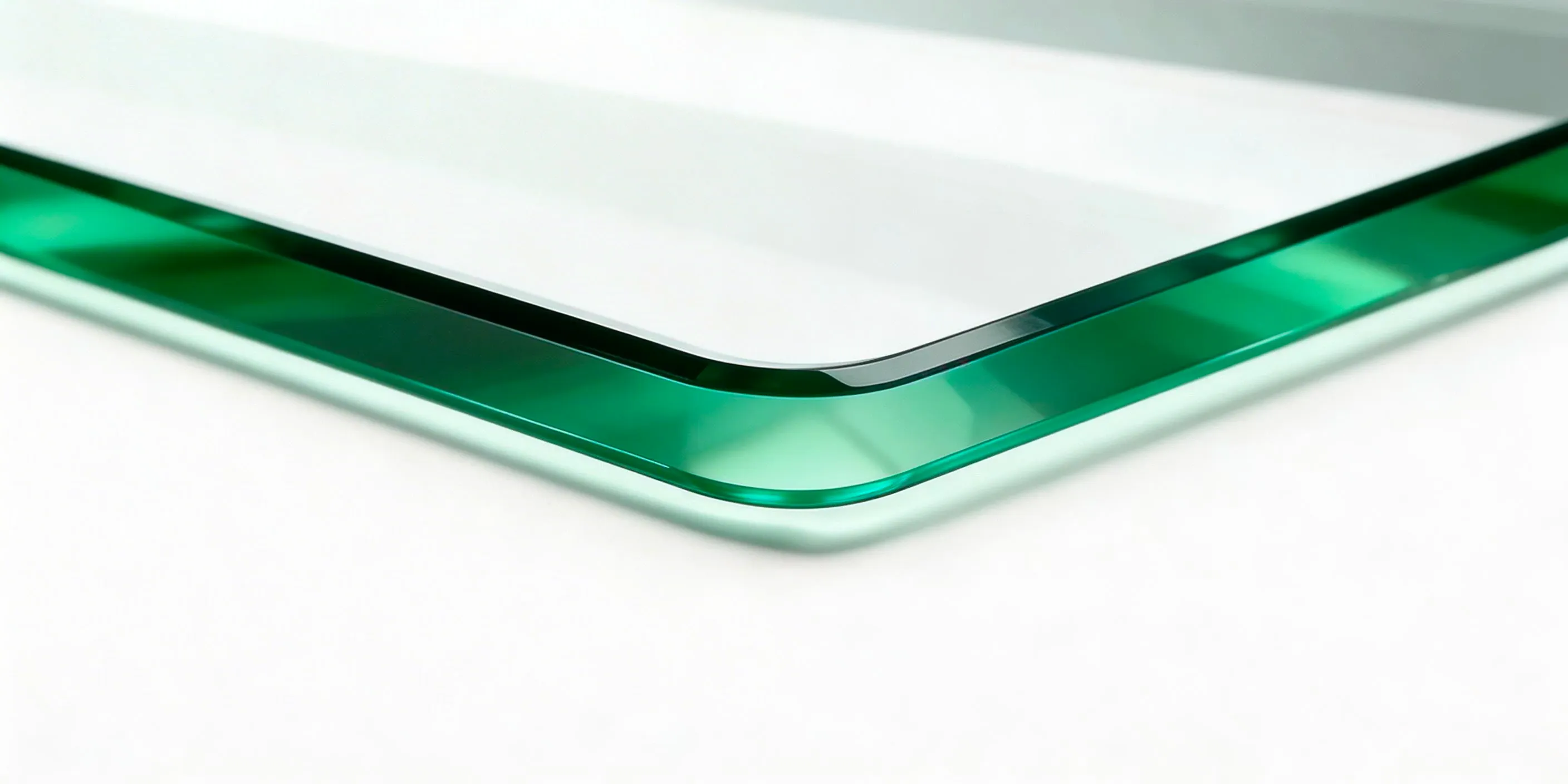 Close-up of stacked glass table tops showing flat polished edges and clear glass thickness.