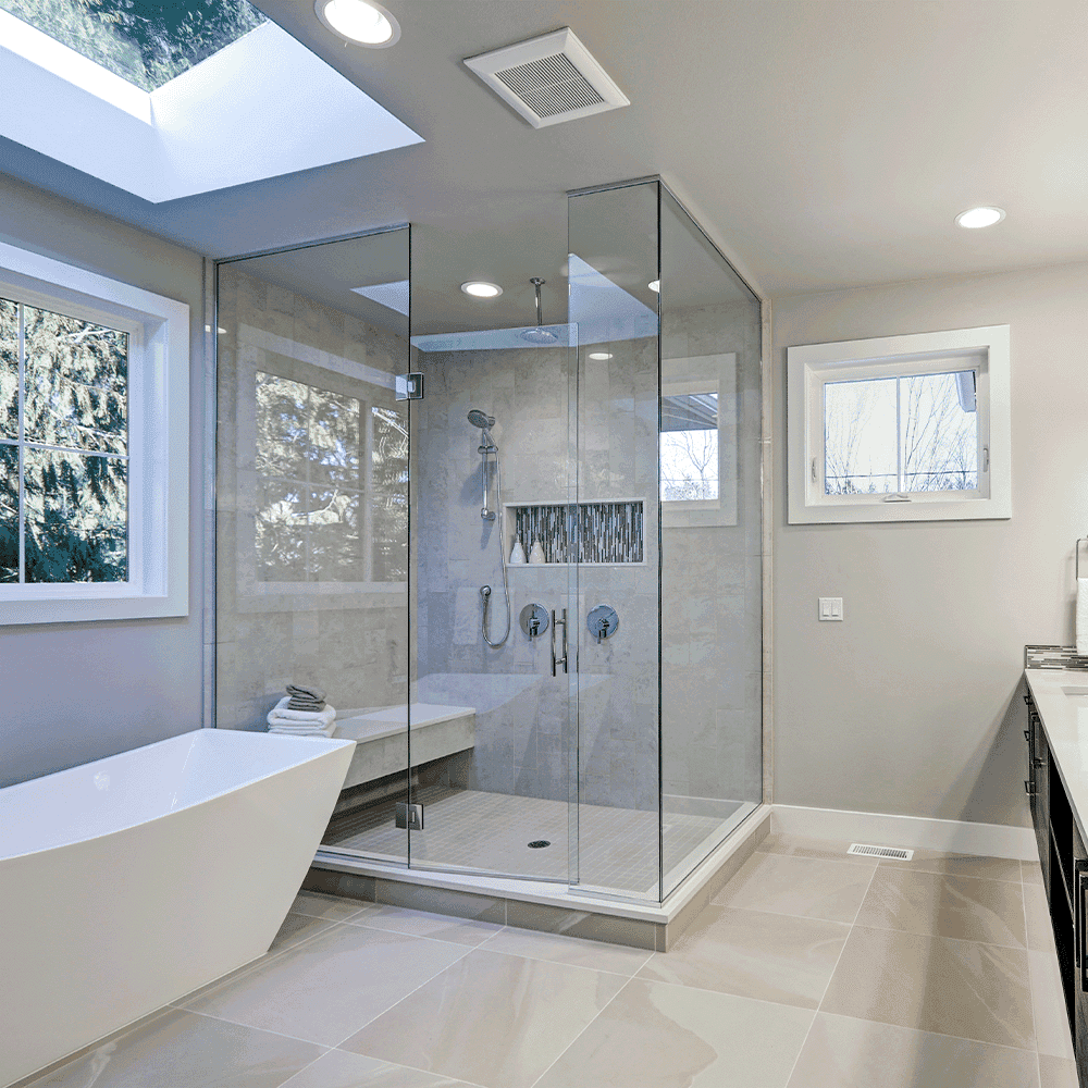 Modern bathroom featuring custom glass shower doors, a sleek freestanding tub, and ample natural light, showcasing quality tempered glass installation.
