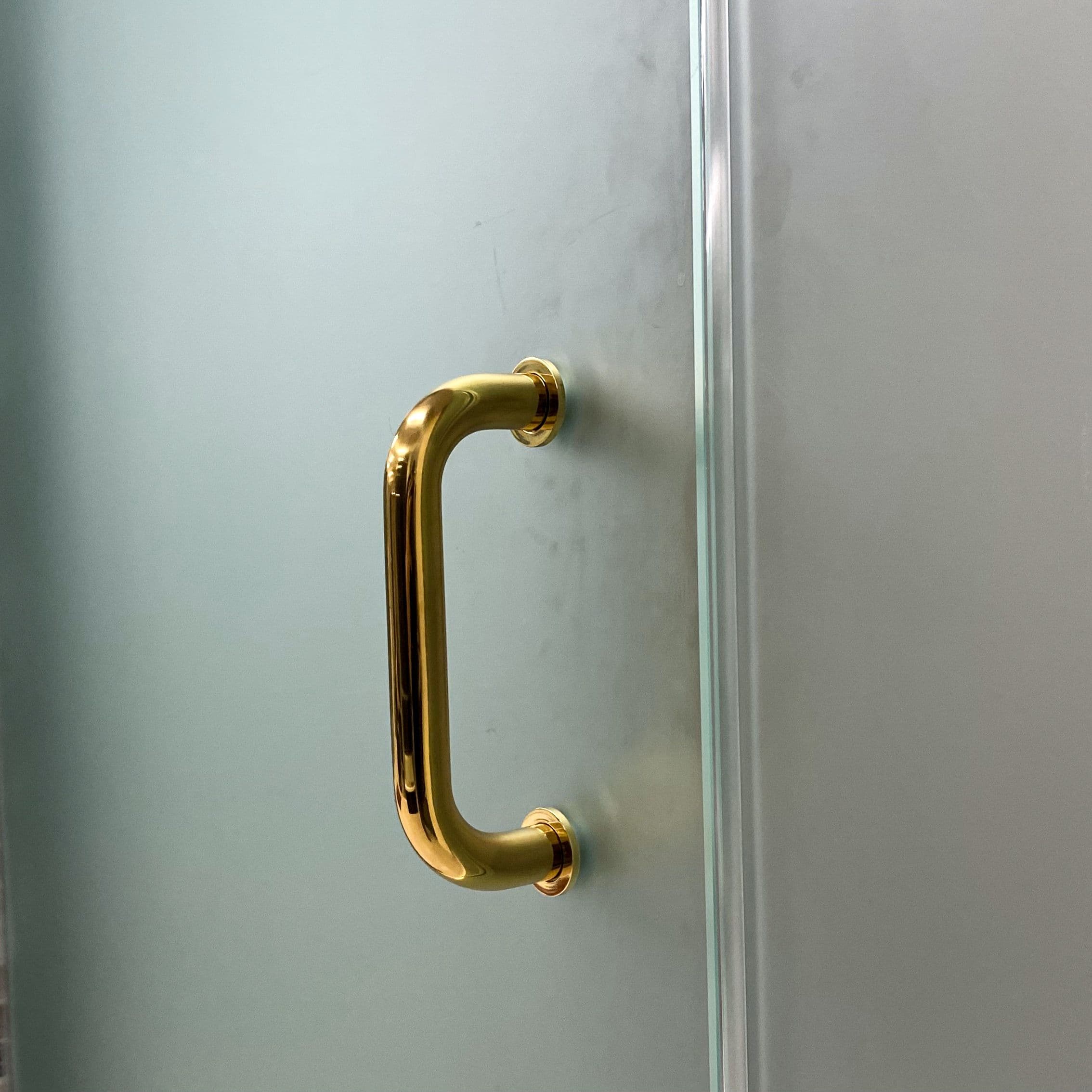 Frosted glass shower door with a gold handle, showcasing custom glass design and quality craftsmanship in tempered glass.