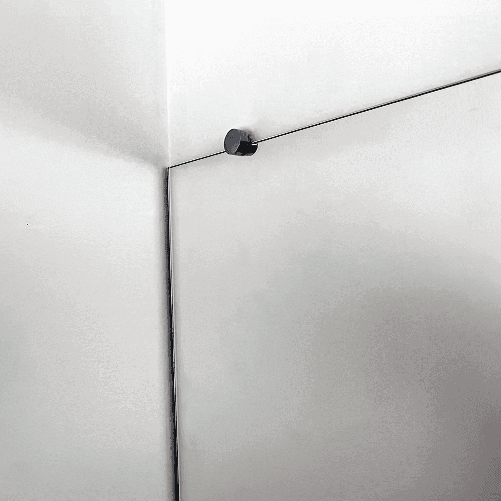 Close-up of custom glass shower door with a sleek beveled edge and minimalist hardware