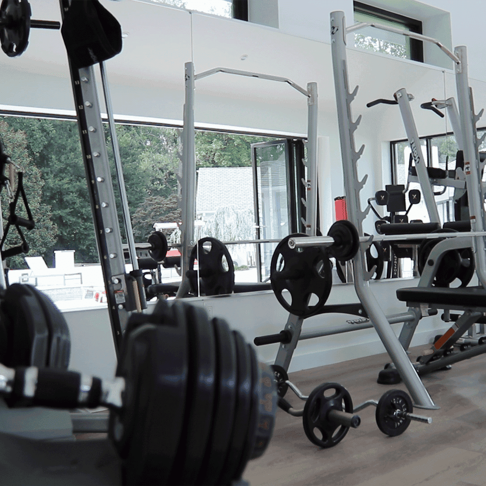 Modern gym featuring custom glass mirrors, showcasing tempered glass design, and stylish beveled glass edges, enhancing the workout environment.