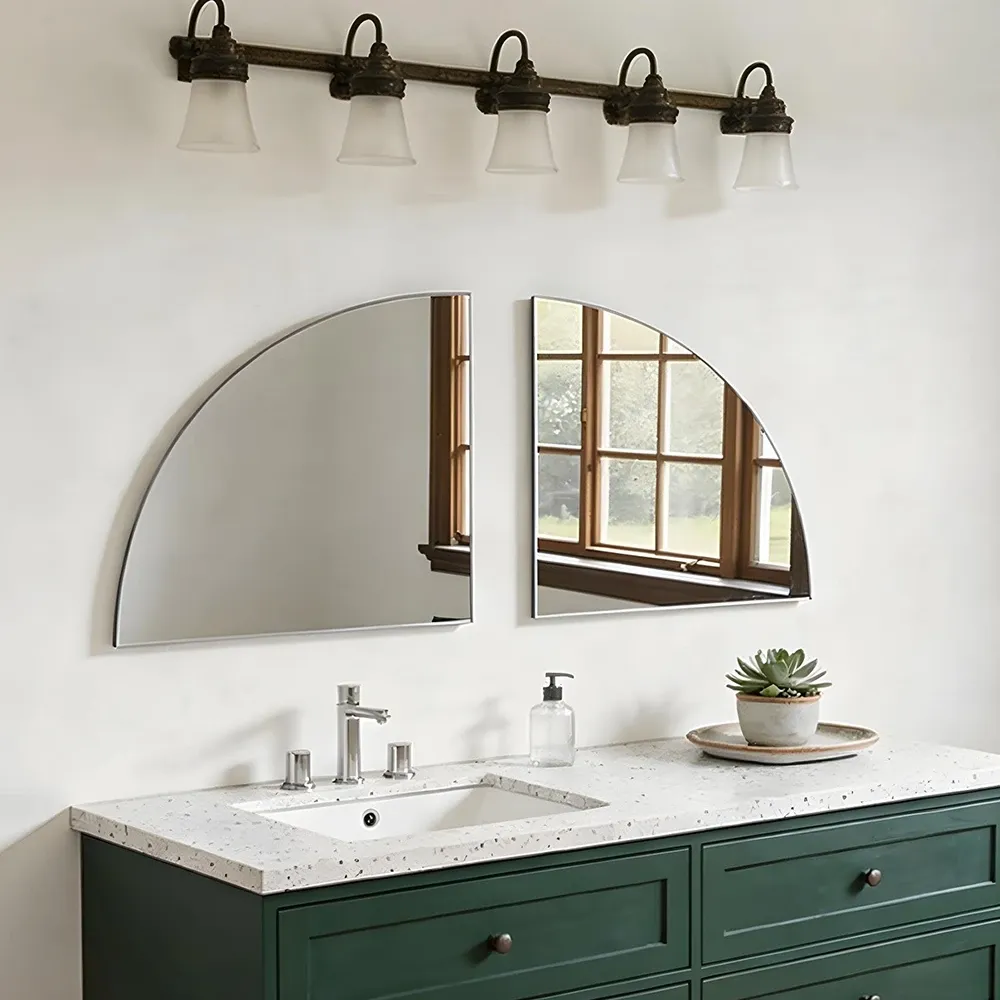 Two quarter-round mirrors forming a split semicircle above a green bathroom vanity