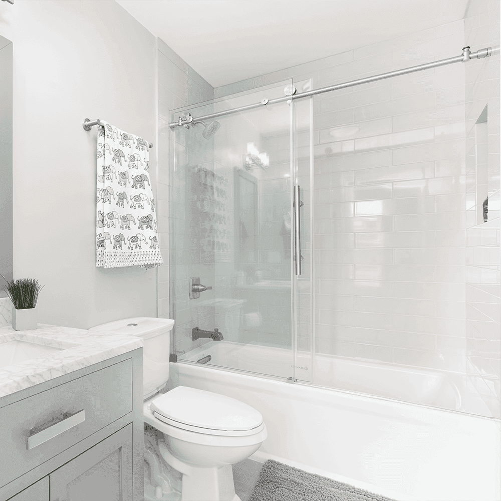 Modern bathroom featuring sleek tempered glass shower doors, stylish marble countertop, and a cozy ambiance, ideal for custom glass solutions including mirrors and table tops.