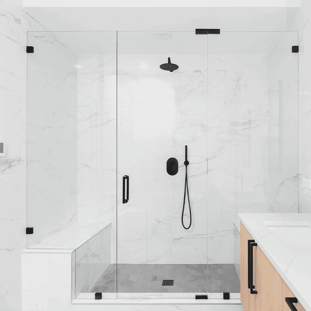 Modern shower doors with tempered glass panels, featuring sleek black hardware, complementing a minimalist bathroom design with marble walls and a stylish shower setup.