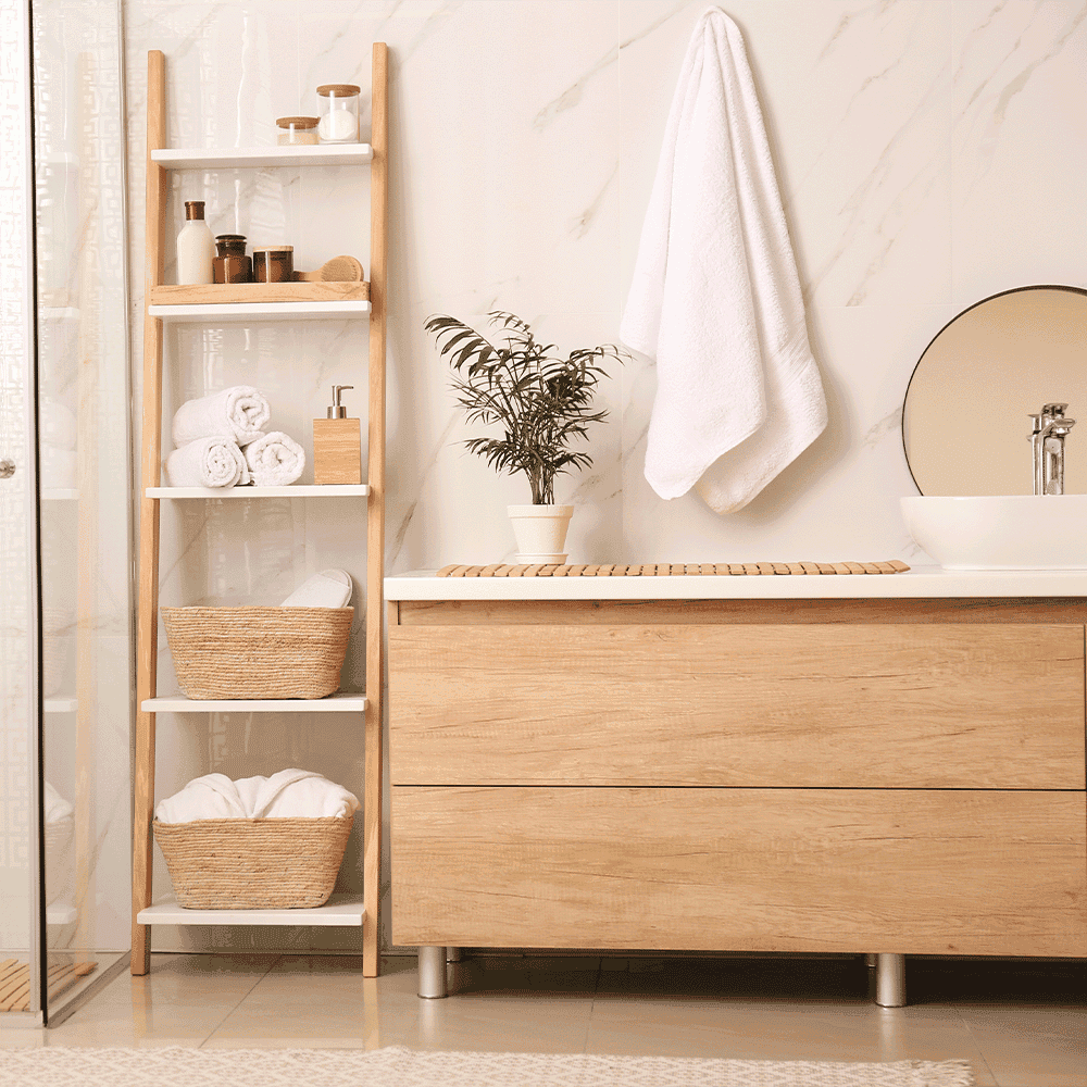 Elegant bathroom scene featuring a round mirror, wooden cabinet, towels, and plant, highlighting custom glass elements like shower doors and sleek tempered glass design.