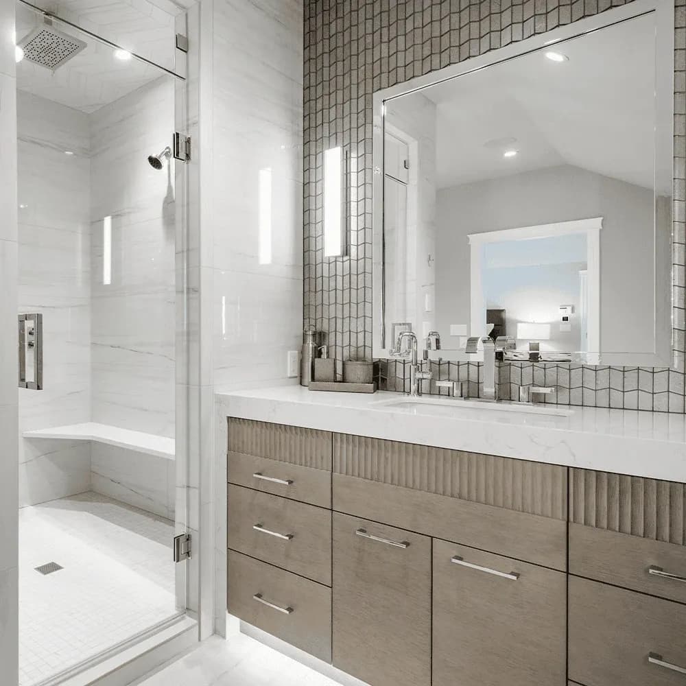A luxury modern bathroom with a marble walk-in shower, a textured wood vanity, and a grey mosaic tile accent wall.