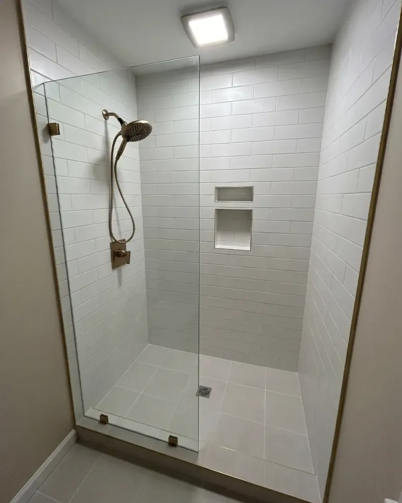 DIY fixed shower screen project with a clear glass panel in a walk-in shower