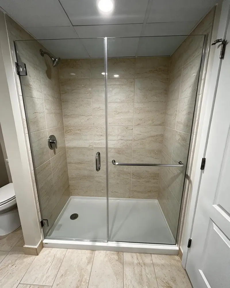 DIY hinged shower door project with frameless glass and installed door hardware