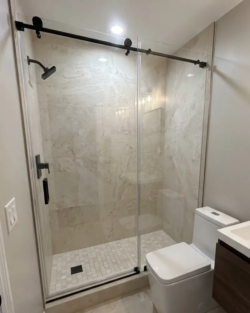 DIY sliding shower door project with finished bathroom tile and glass door hardware
